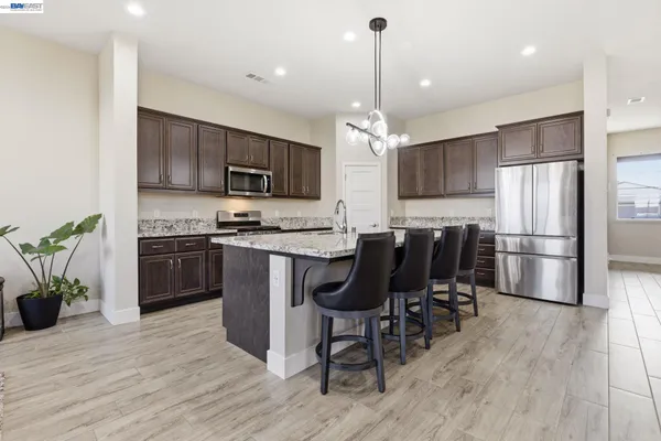 a kitchen with stainless steel appliances granite countertop wooden cabinets a stove top oven a sink and dishwasher