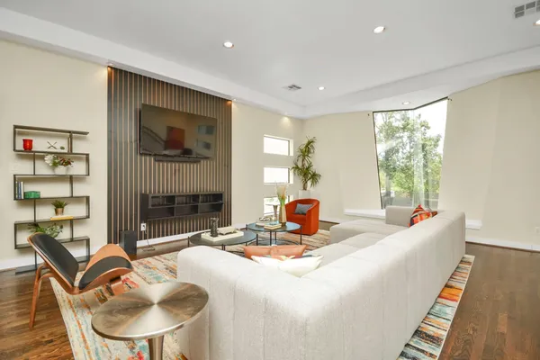 a living room with fireplace furniture and a large window