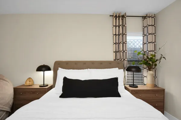 a bedroom with a bed and a potted plant