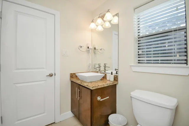 a bathroom with a granite countertop sink toilet and mirror