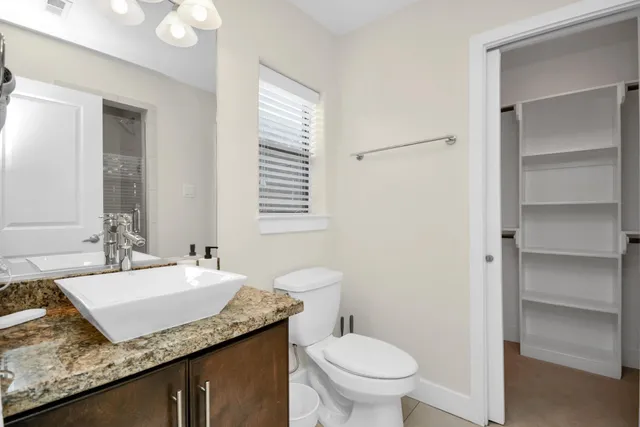 a bathroom with a granite countertop sink and a mirror