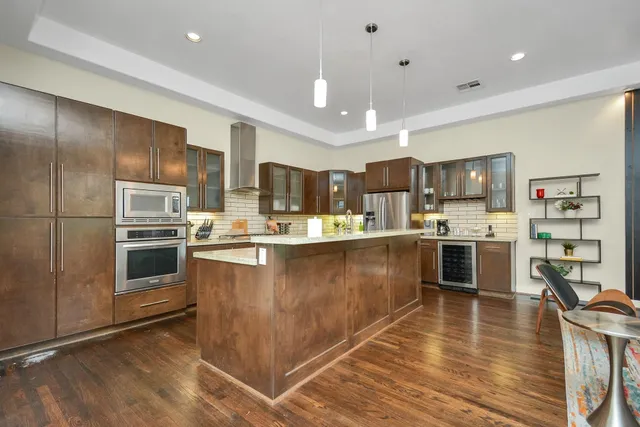 a kitchen with kitchen island a counter top space a sink stainless steel appliances and cabinets
