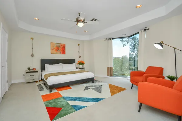 a bedroom with furniture and a large window