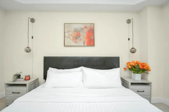 a bedroom with a bed and a painting on the wall