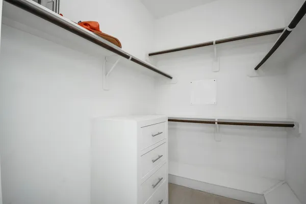 a view of walk in closet with empty racks