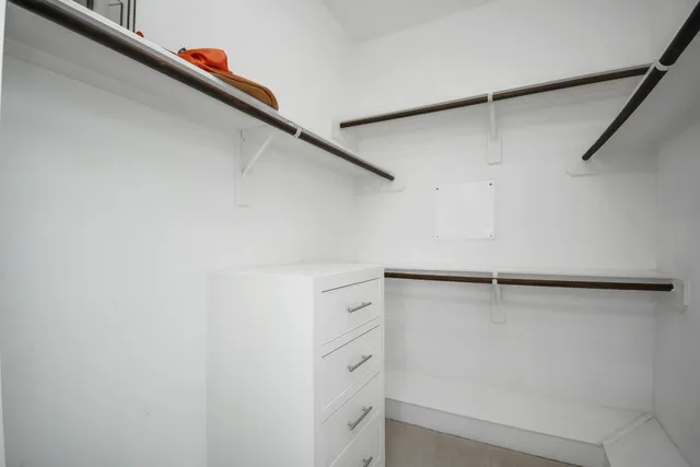 a view of walk in closet with empty racks