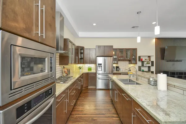 a large kitchen with a large counter top appliances and cabinets