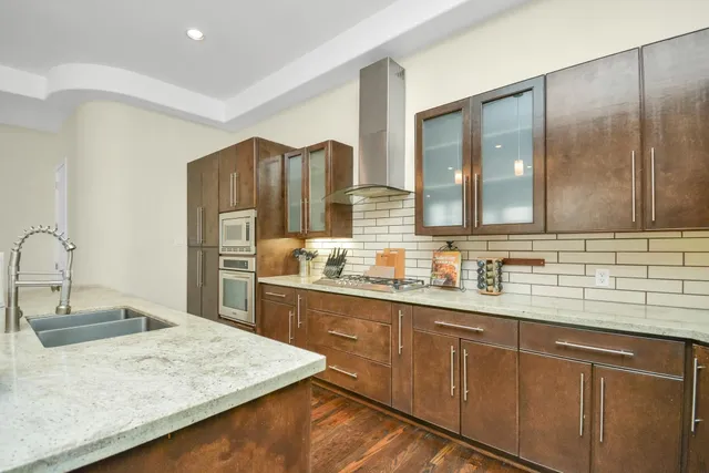 a kitchen with stainless steel appliances granite countertop a sink a stove and refrigerator