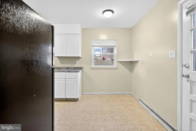 a kitchen with granite countertop white cabinets and stainless steel appliances