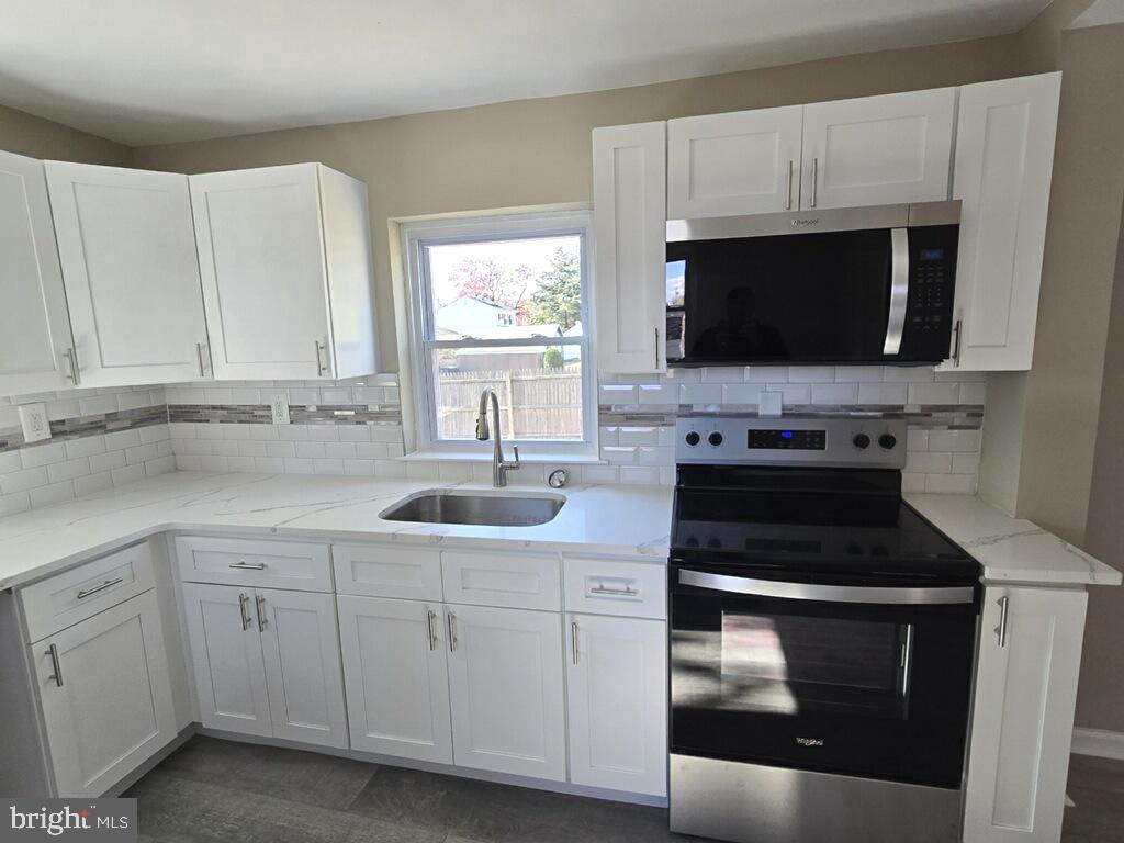 524 8th Avenue Lindenwold, NJ 08021 - Photo 11 of 22 a kitchen with white cabinets stainless steel appliances and sink