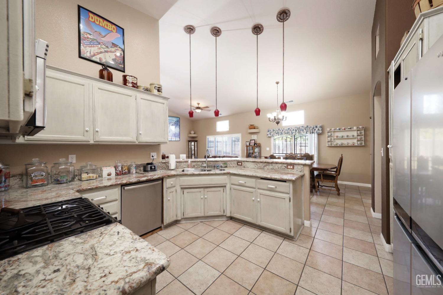 Undisclosed Address Bakersfield, CA 93312 - Photo 13 of 38 a kitchen with kitchen island granite countertop a sink and cabinets