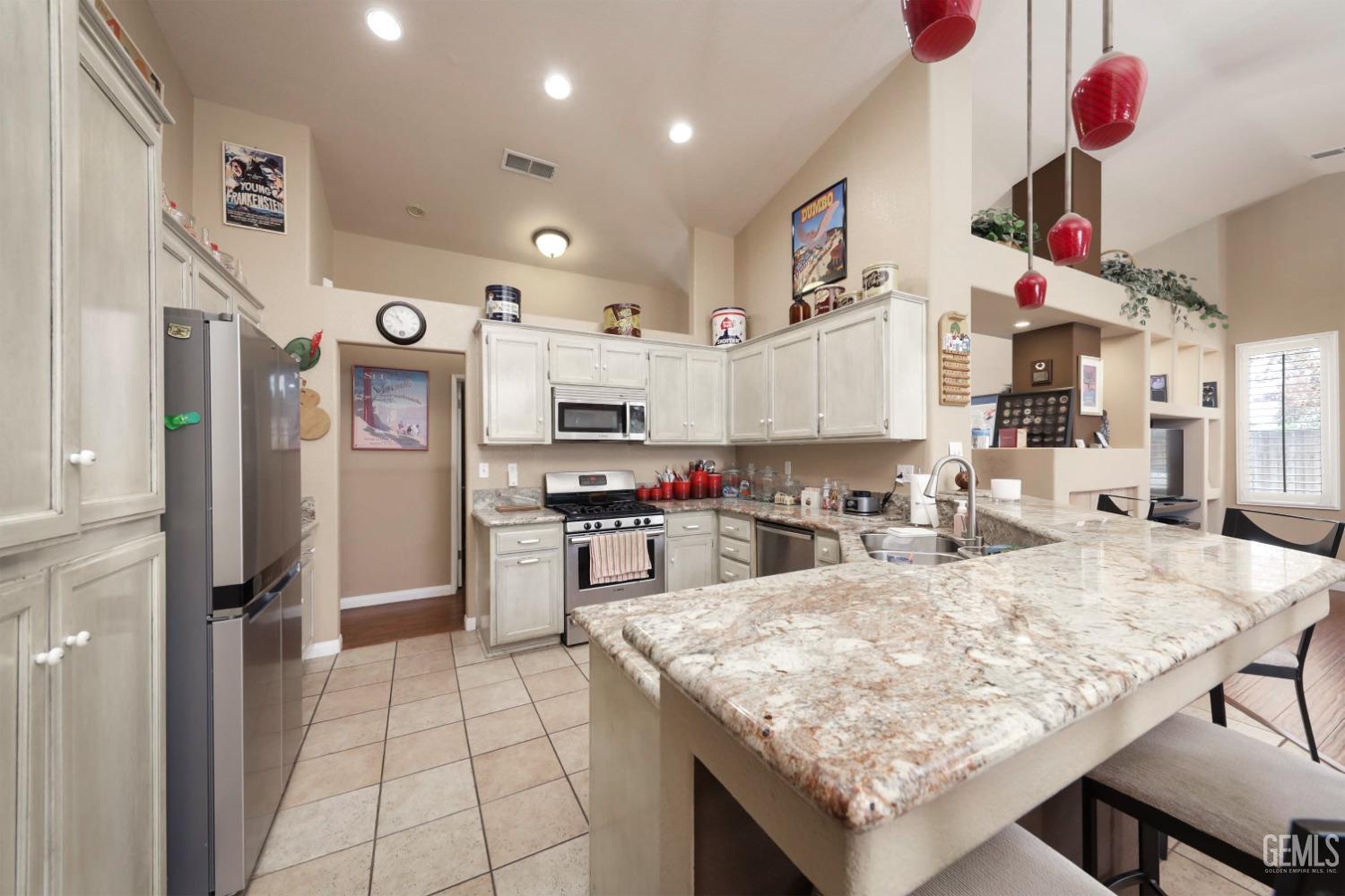 Undisclosed Address Bakersfield, CA 93312 - Photo 14 of 38 a kitchen with stainless steel appliances granite countertop a sink refrigerator and microwave