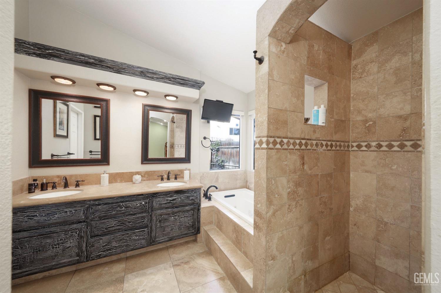 Undisclosed Address Bakersfield, CA 93312 - Photo 23 of 38 a spacious bathroom with a double vanity sink mirror double and bathtub