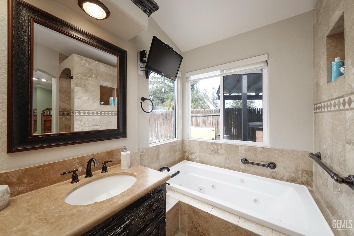 Undisclosed Address Bakersfield, CA 93312 - Photo 25 of 38 a bathroom with a granite countertop tub sink and mirror