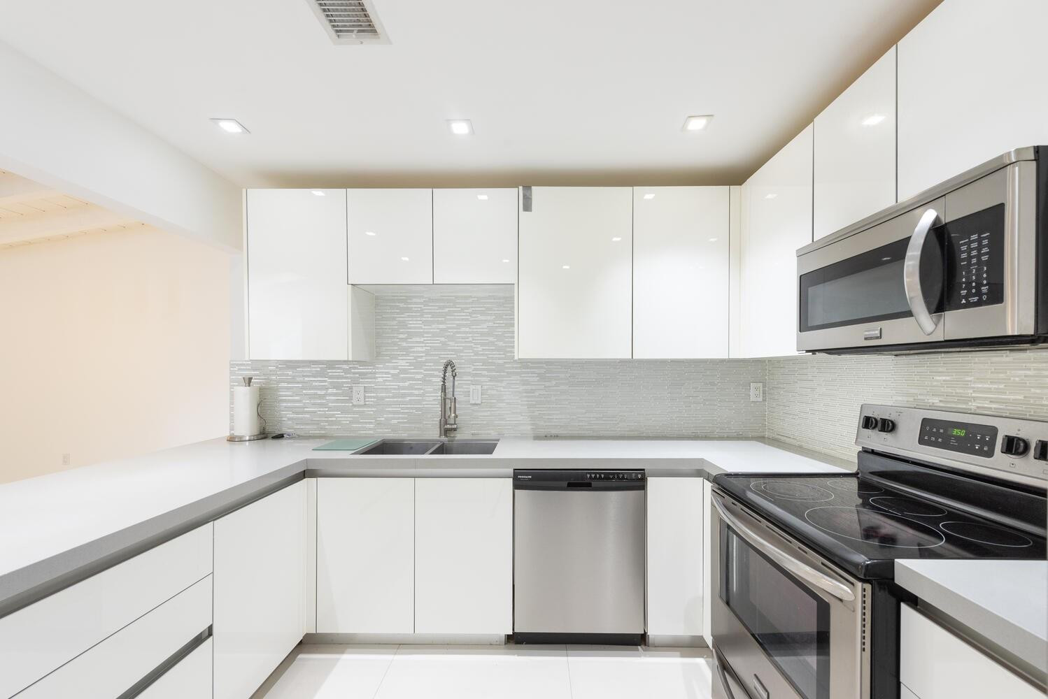6604 Southwest 114th Place, Unit C72 Miami, FL 33173 - Photo 11 of 28 a kitchen with kitchen island granite countertop a sink stainless steel appliances and cabinets