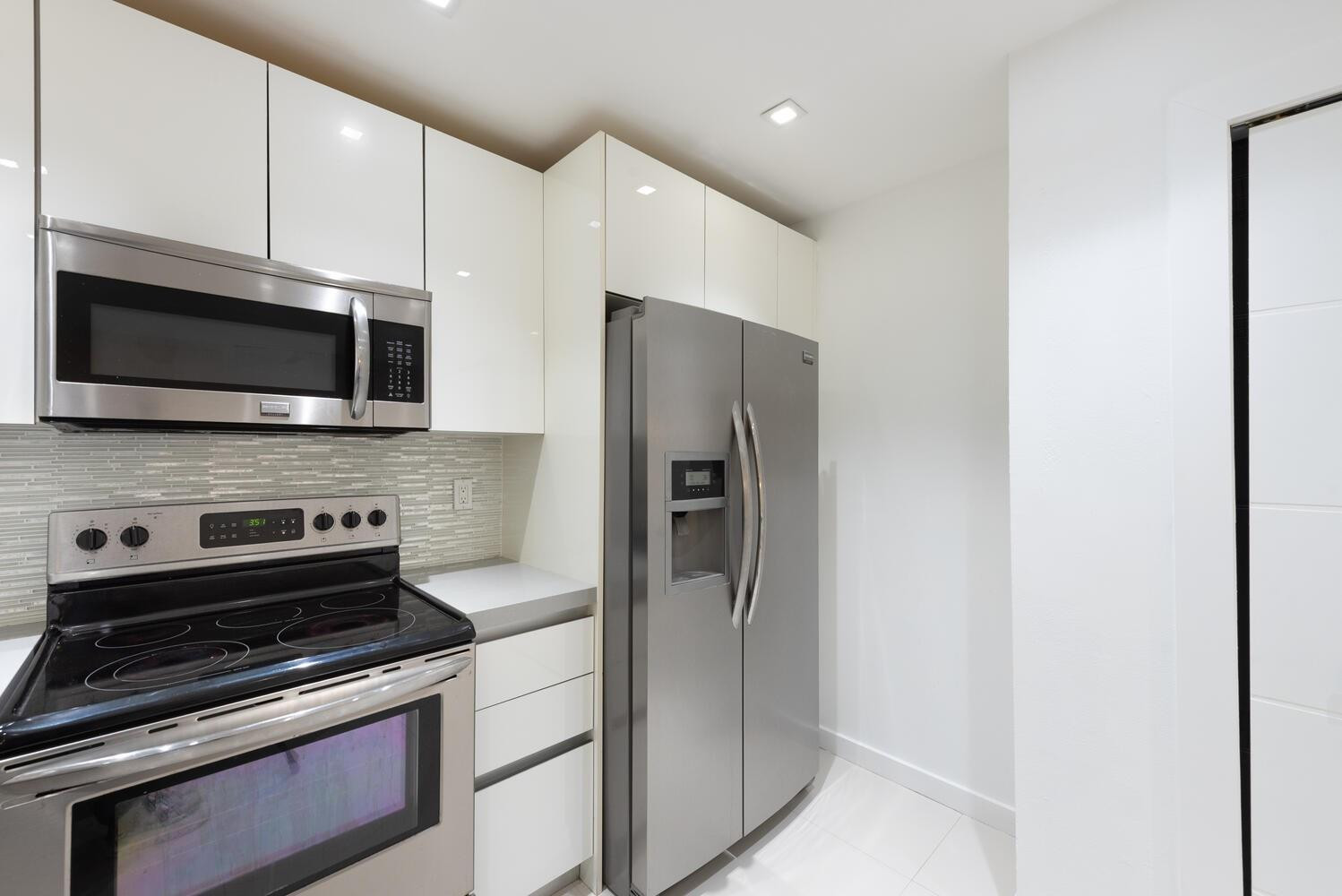 6604 Southwest 114th Place, Unit C72 Miami, FL 33173 - Photo 13 of 28 a kitchen with stainless steel appliances a stove microwave and refrigerator