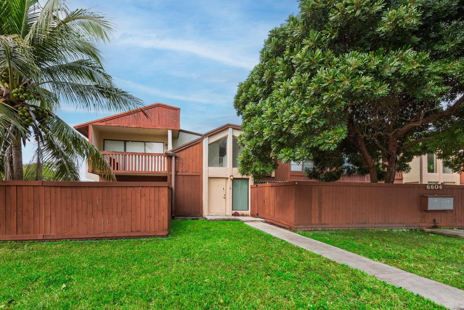 6604 Southwest 114th Place, Unit C72 Miami, FL 33173 - Photo 3 of 28 a view of backyard with wooden fence and a large tree