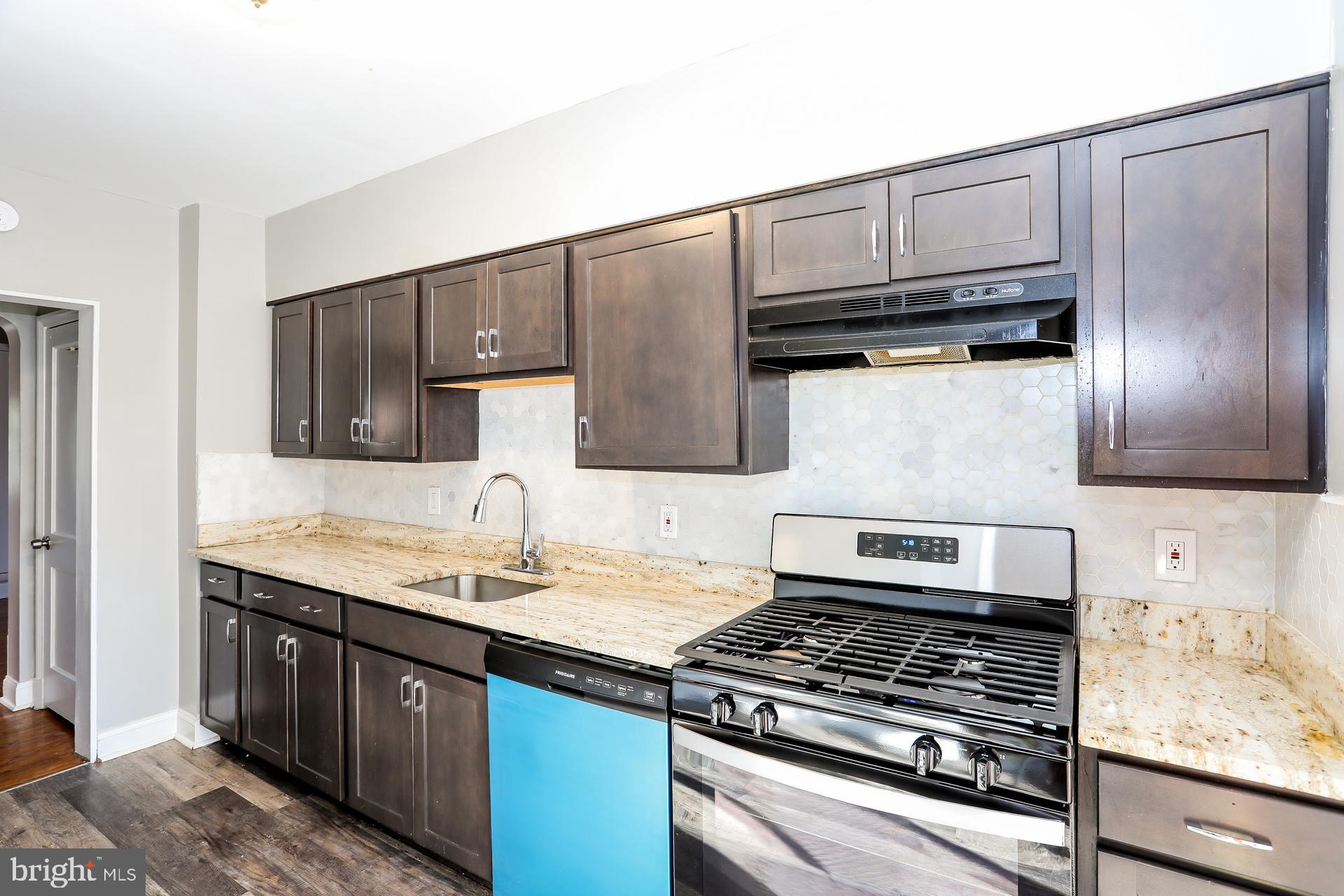 5911 Ayleshire Road Baltimore, MD 21239 - Photo 3 of 10 a kitchen with granite countertop a stove sink and cabinets