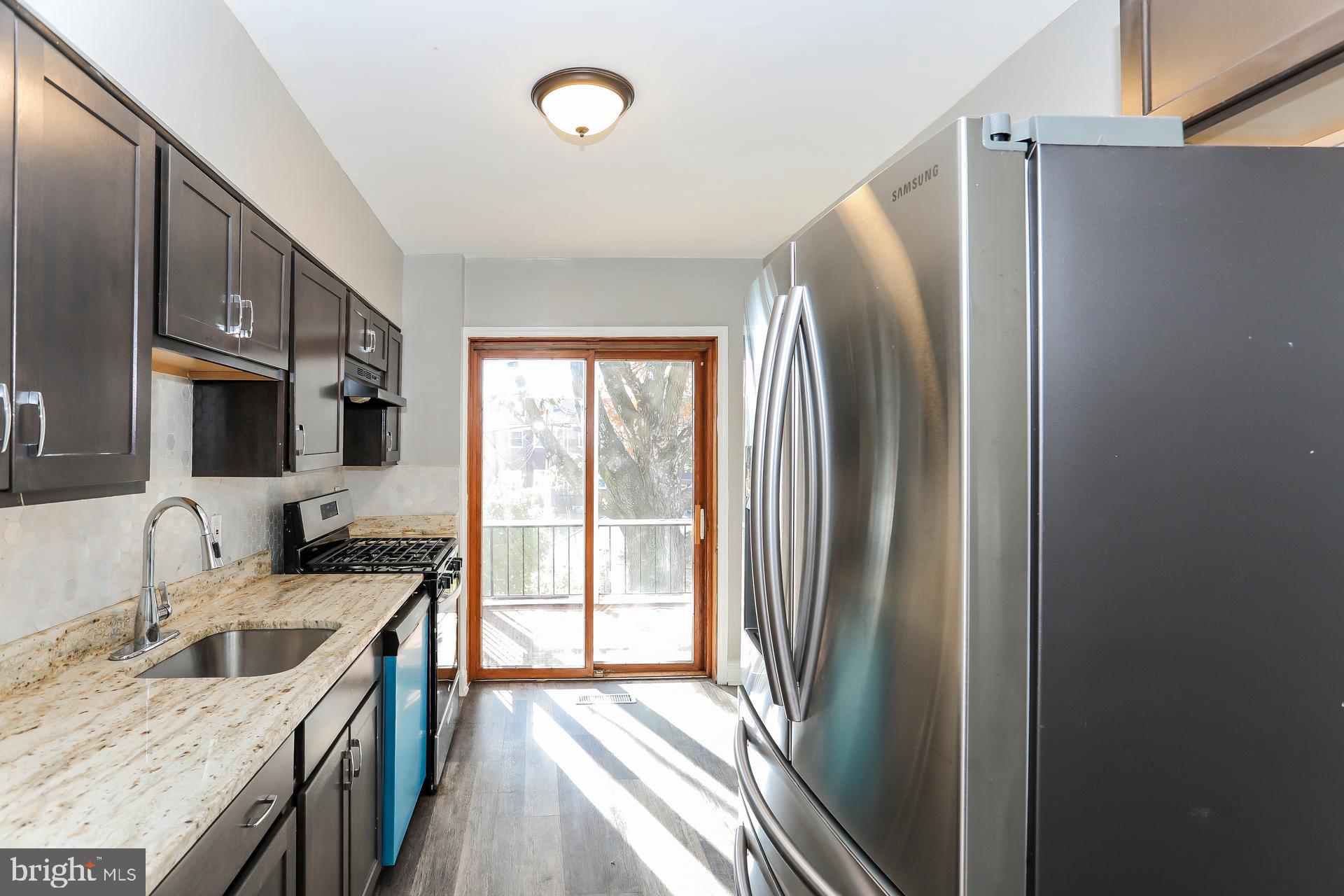 5911 Ayleshire Road Baltimore, MD 21239 - Photo 4 of 10 a kitchen with stainless steel appliances granite countertop a refrigerator a sink and a stove