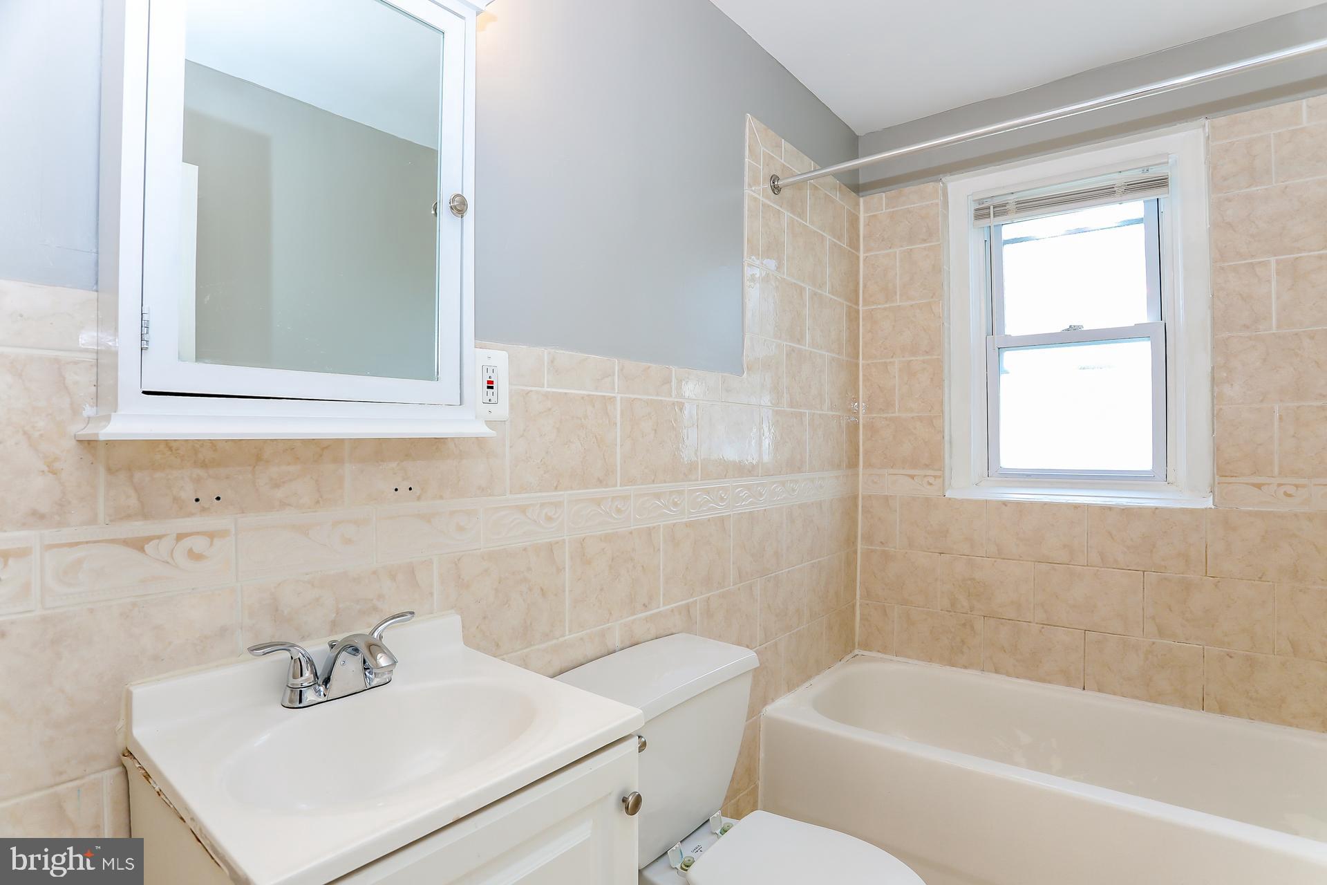5911 Ayleshire Road Baltimore, MD 21239 - Photo 6 of 10 a bathroom with a sink a toilet and shower