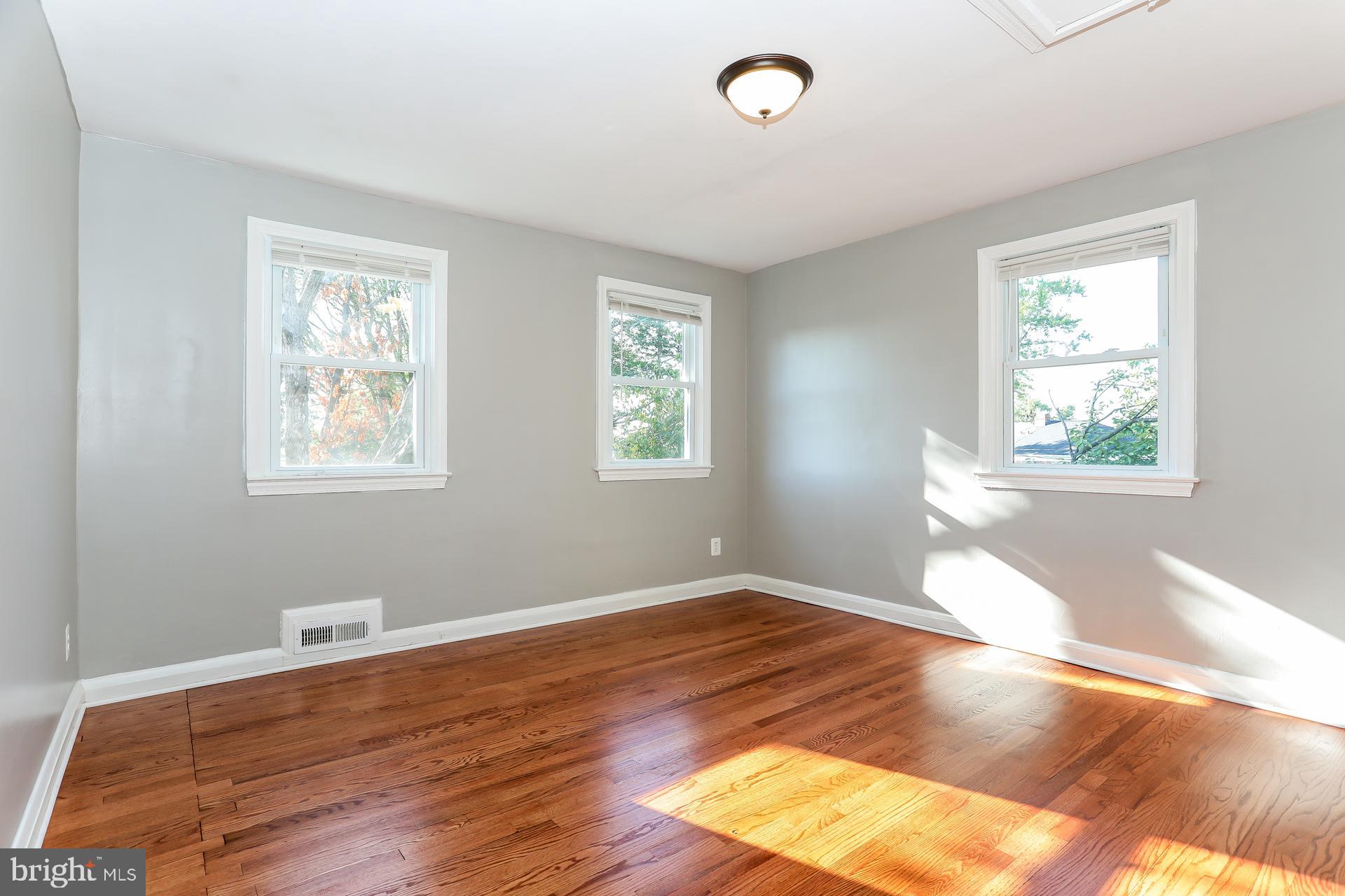 5911 Ayleshire Road Baltimore, MD 21239 - Photo 8 of 10 a view of empty room with wooden floor and fan