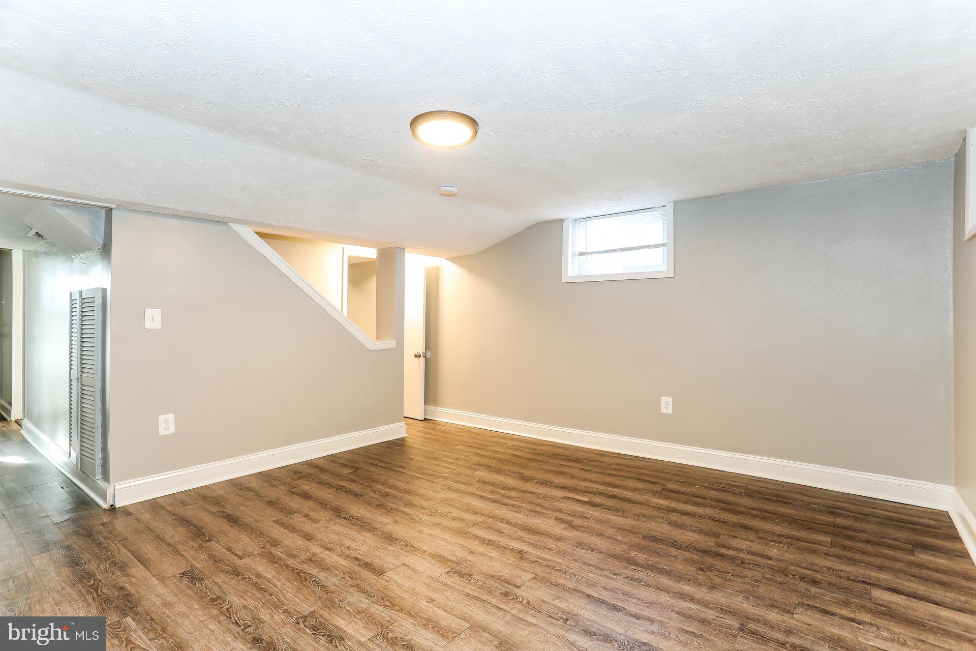 5911 Ayleshire Road Baltimore, MD 21239 - Photo 9 of 10 a view of an empty room with wooden floor and a window