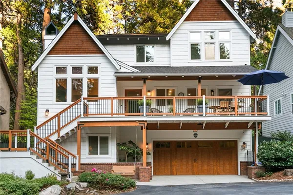 a view of a white house with large windows and a small yard