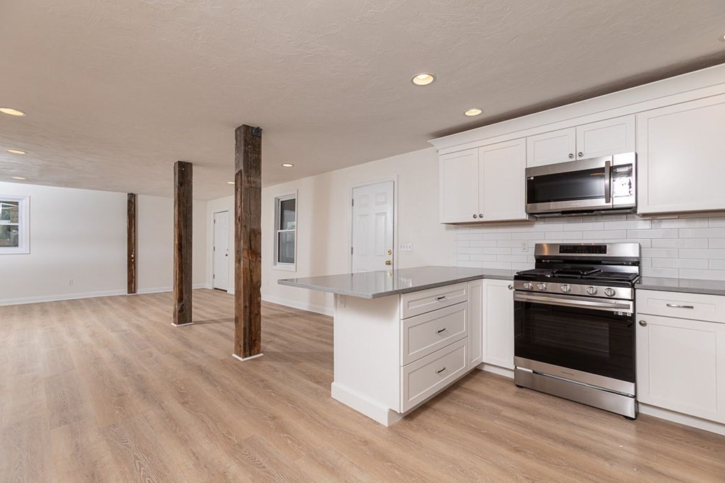 4 Farragut Road, Unit 1 Ipswich, MA 01938 - Photo 3 of 13 a kitchen with stainless steel appliances a stove top oven a sink and a refrigerator