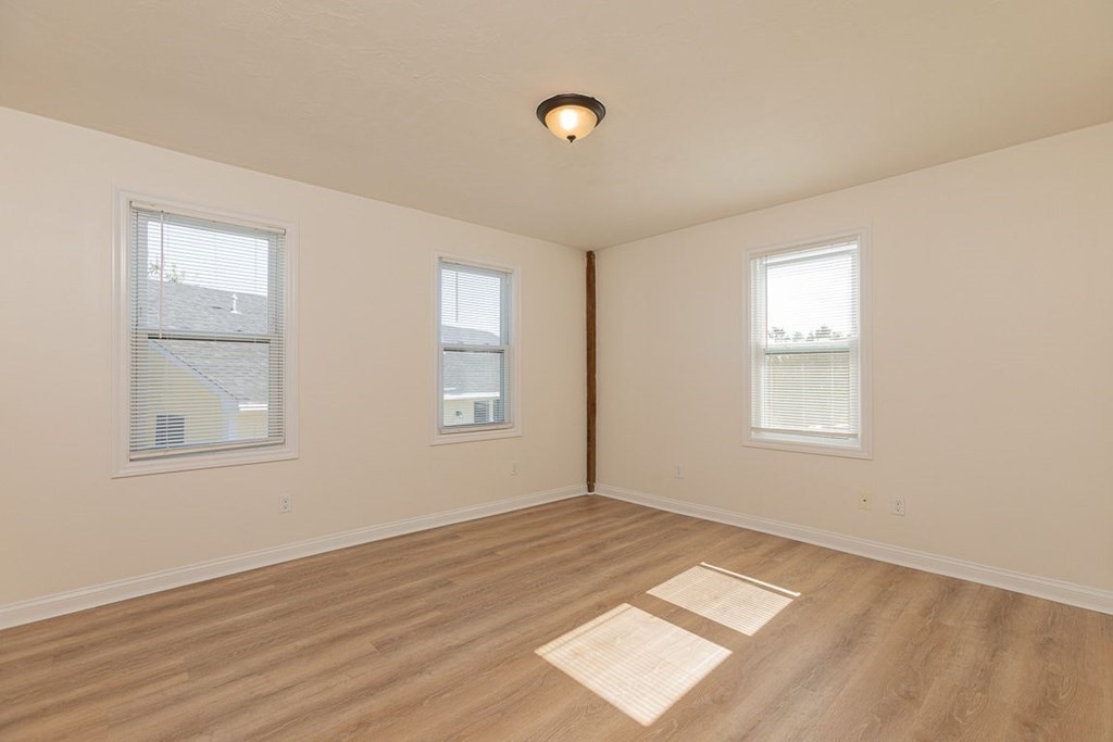 4 Farragut Road, Unit 1 Ipswich, MA 01938 - Photo 7 of 13 an empty room with wooden floor and windows
