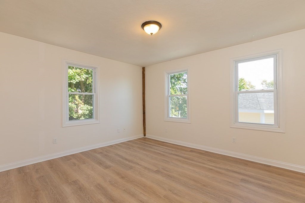 4 Farragut Road, Unit 1 Ipswich, MA 01938 - Photo 8 of 13 a view of an empty room with wooden floor and a window