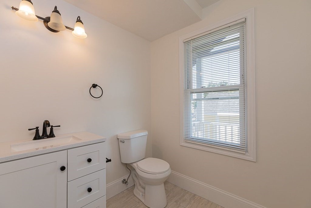 4 Farragut Road, Unit 1 Ipswich, MA 01938 - Photo 10 of 13 a bathroom with a toilet sink vanity and window