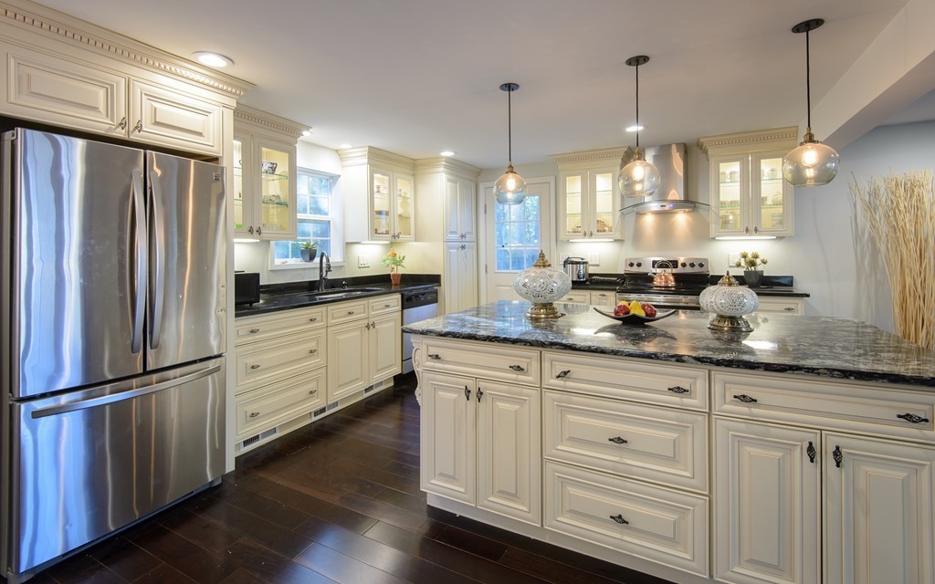 a kitchen with granite countertop a refrigerator a sink and wooden floor