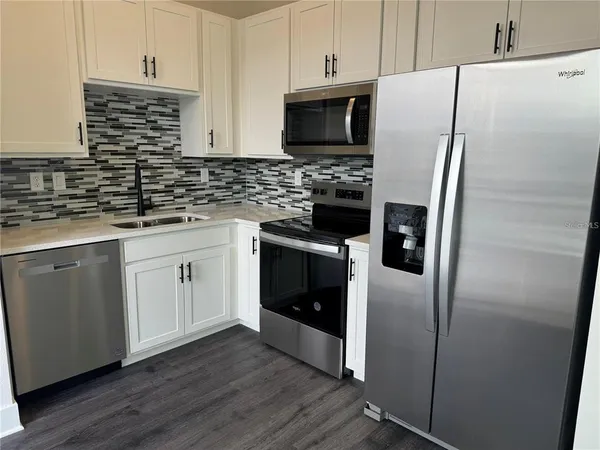 a stove top oven sitting inside of a kitchen