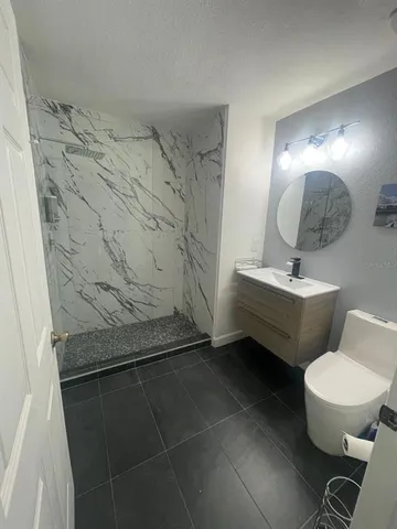 a bathroom with a sink toilet and mirror