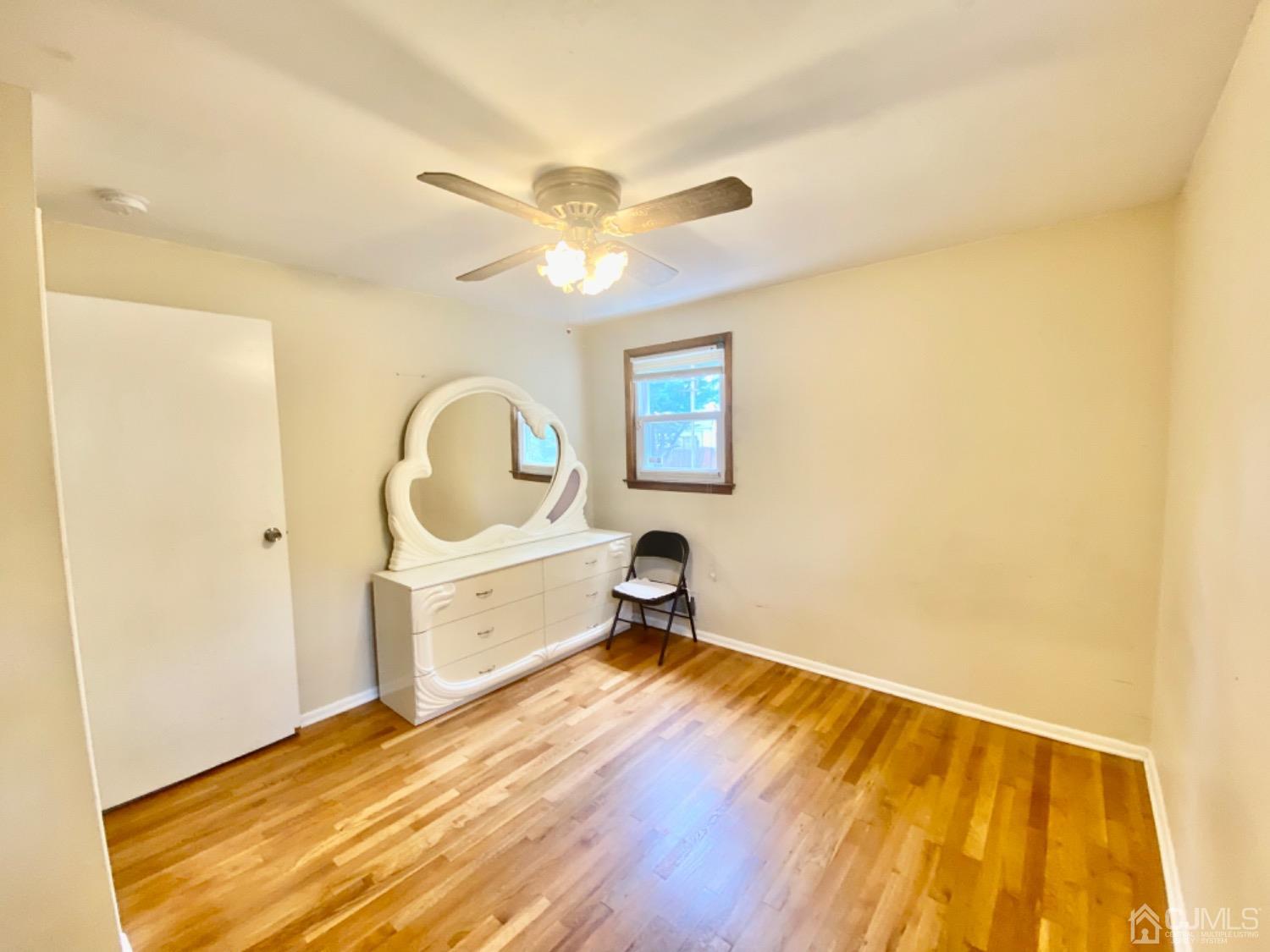 91 Holly Road Iselin, NJ 08830 - Photo 13 of 25 a bedroom with a bed and a chandelier