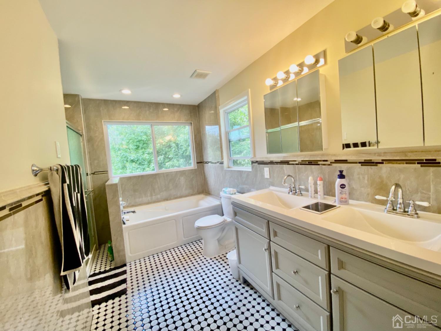 91 Holly Road Iselin, NJ 08830 - Photo 14 of 25 a bathroom with a sink a toilet and a mirror