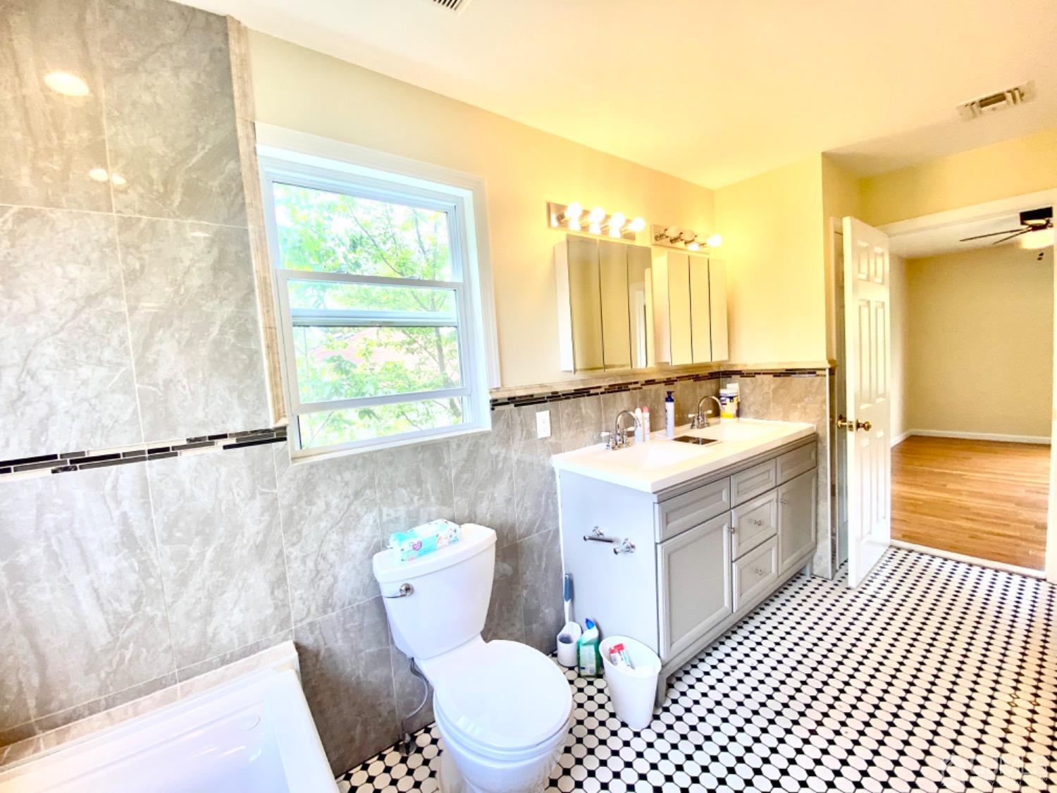 91 Holly Road Iselin, NJ 08830 - Photo 17 of 25 a bathroom with a sink a mirror and a bathtub
