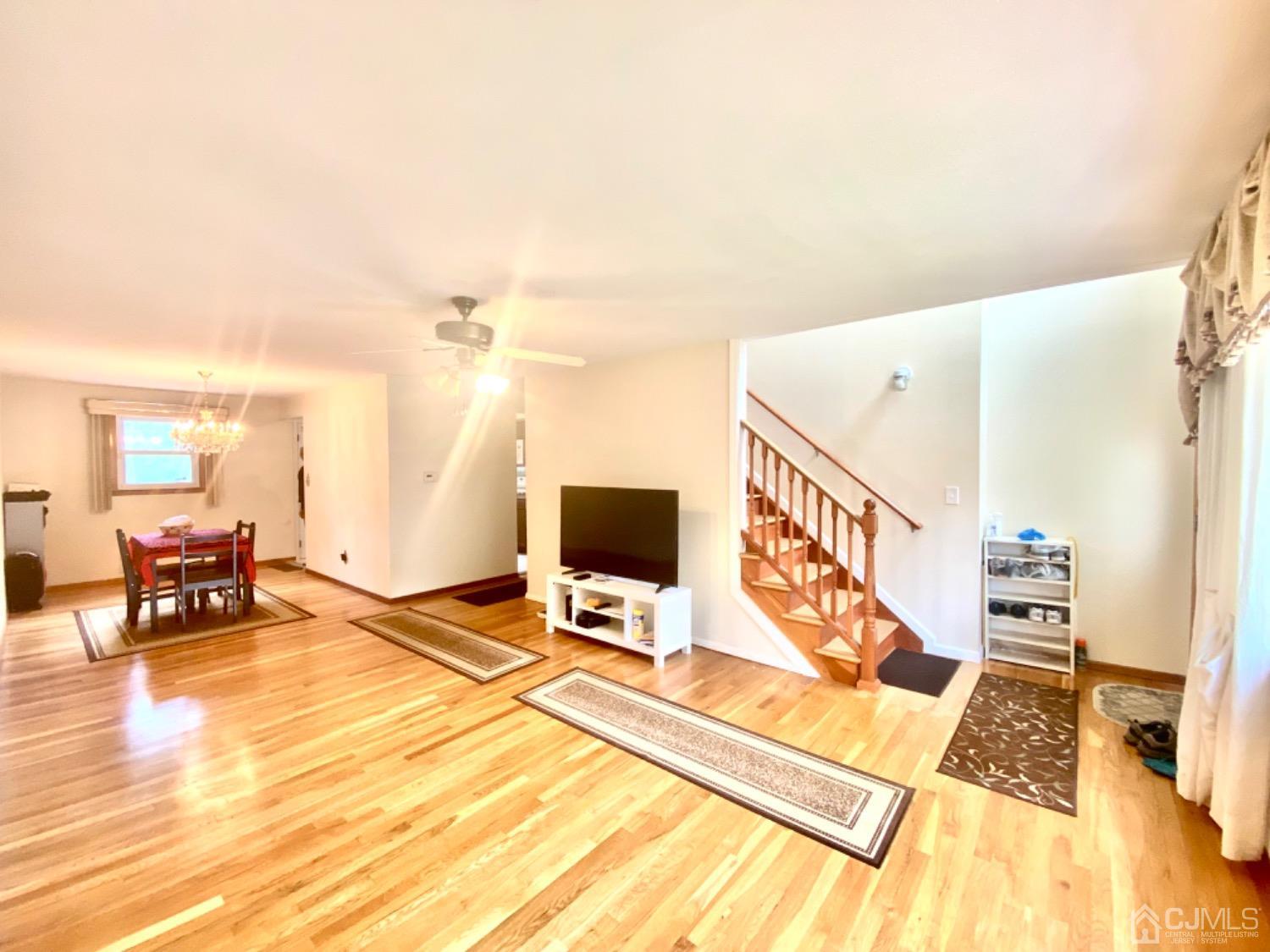 91 Holly Road Iselin, NJ 08830 - Photo 4 of 25 a view of a living room with a flat screen tv and floor to ceiling window