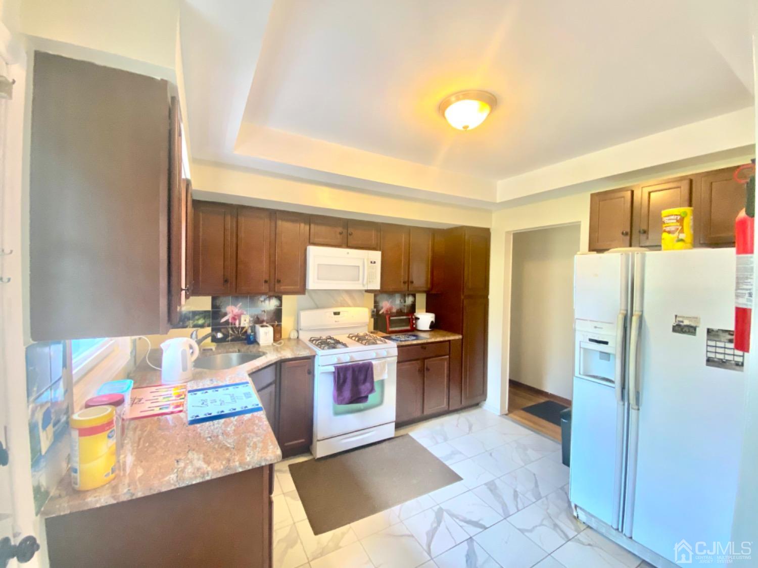 91 Holly Road Iselin, NJ 08830 - Photo 6 of 25 a kitchen with a refrigerator and a stove top oven