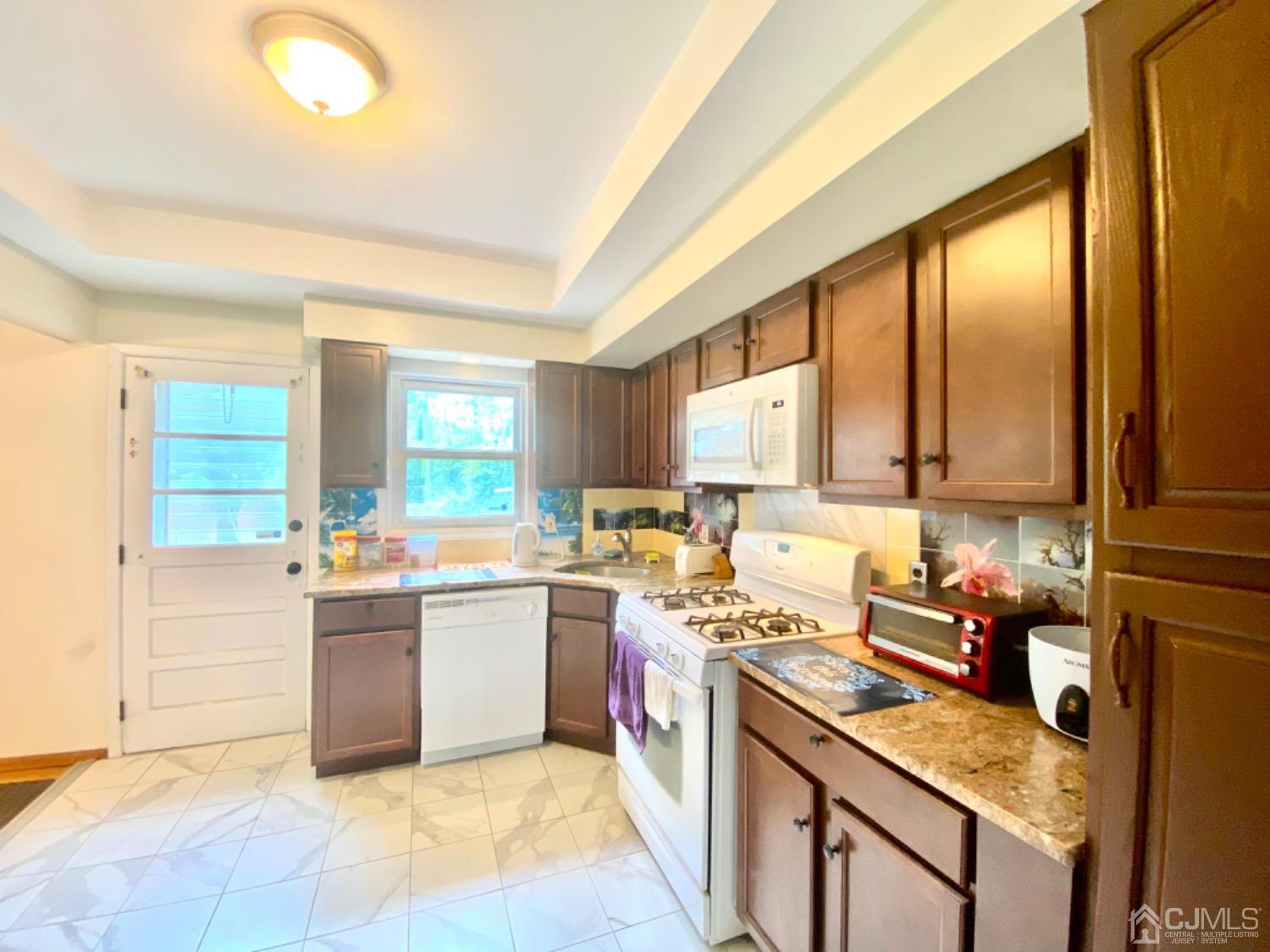 91 Holly Road Iselin, NJ 08830 - Photo 7 of 25 a kitchen with a sink stove and cabinets
