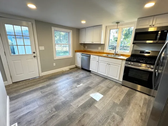 a kitchen with stainless steel appliances kitchen island granite countertop a stove a sink and a microwave