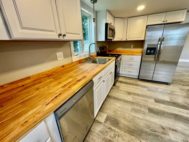 a kitchen with stainless steel appliances granite countertop a stove a sink and a refrigerator