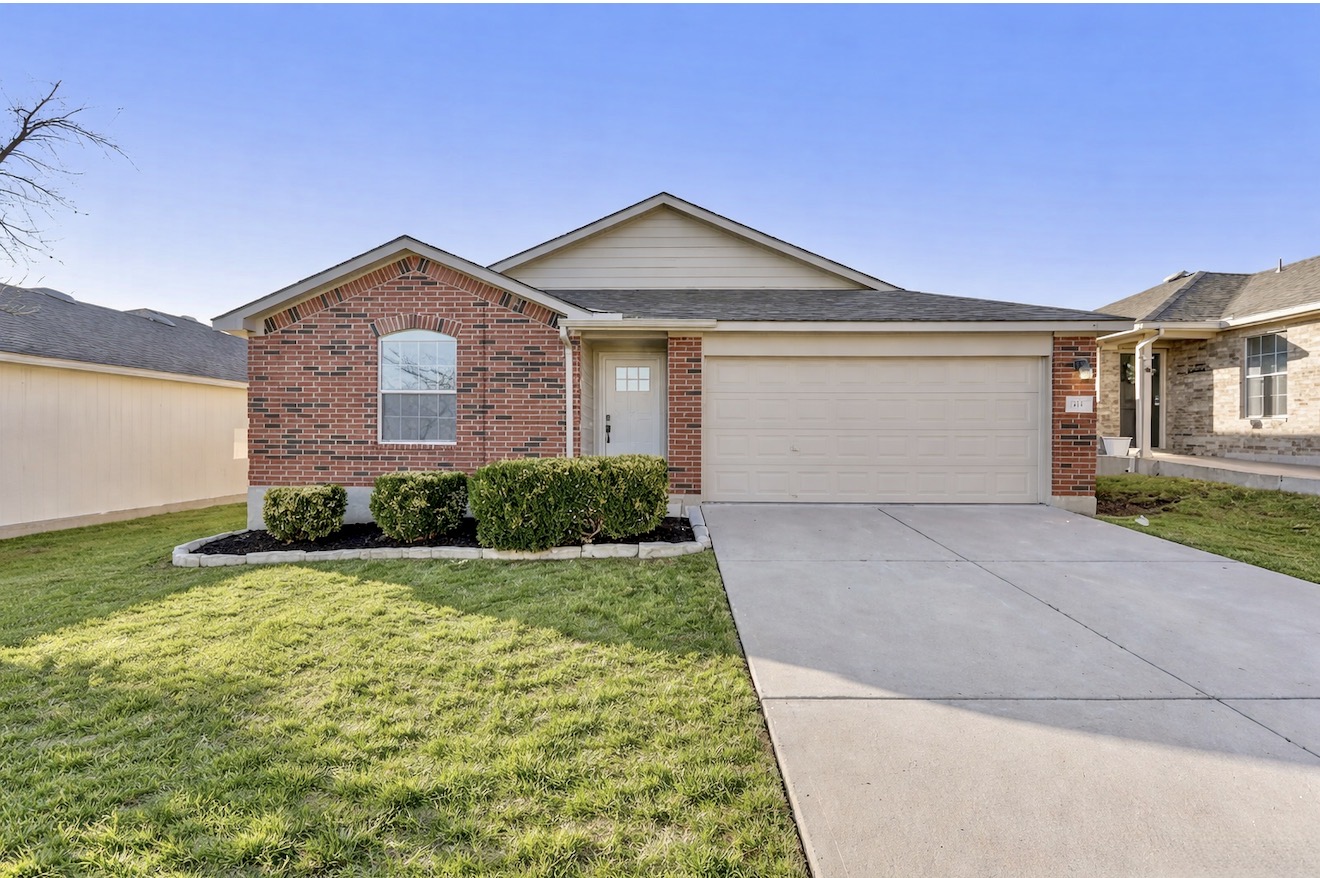 313 Drystone Trail Liberty Hill, TX 78642 - Photo 1 of 17 Ranch-style home featuring brick siding, an attached garage, driveway, and a front lawn