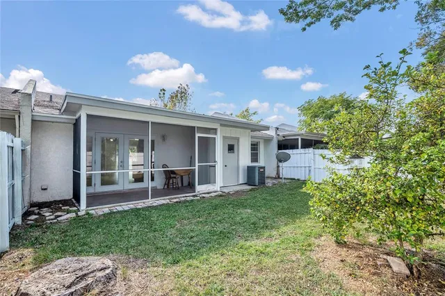 a view of backyard with wooden fence and a tree