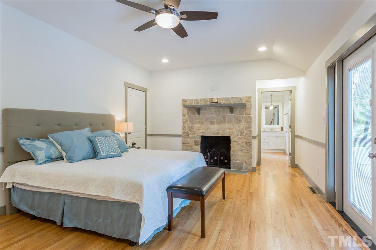 409 Stacy Street Raleigh, NC 27607 - Photo 3 of 25 a bed room with a bed and a fireplace