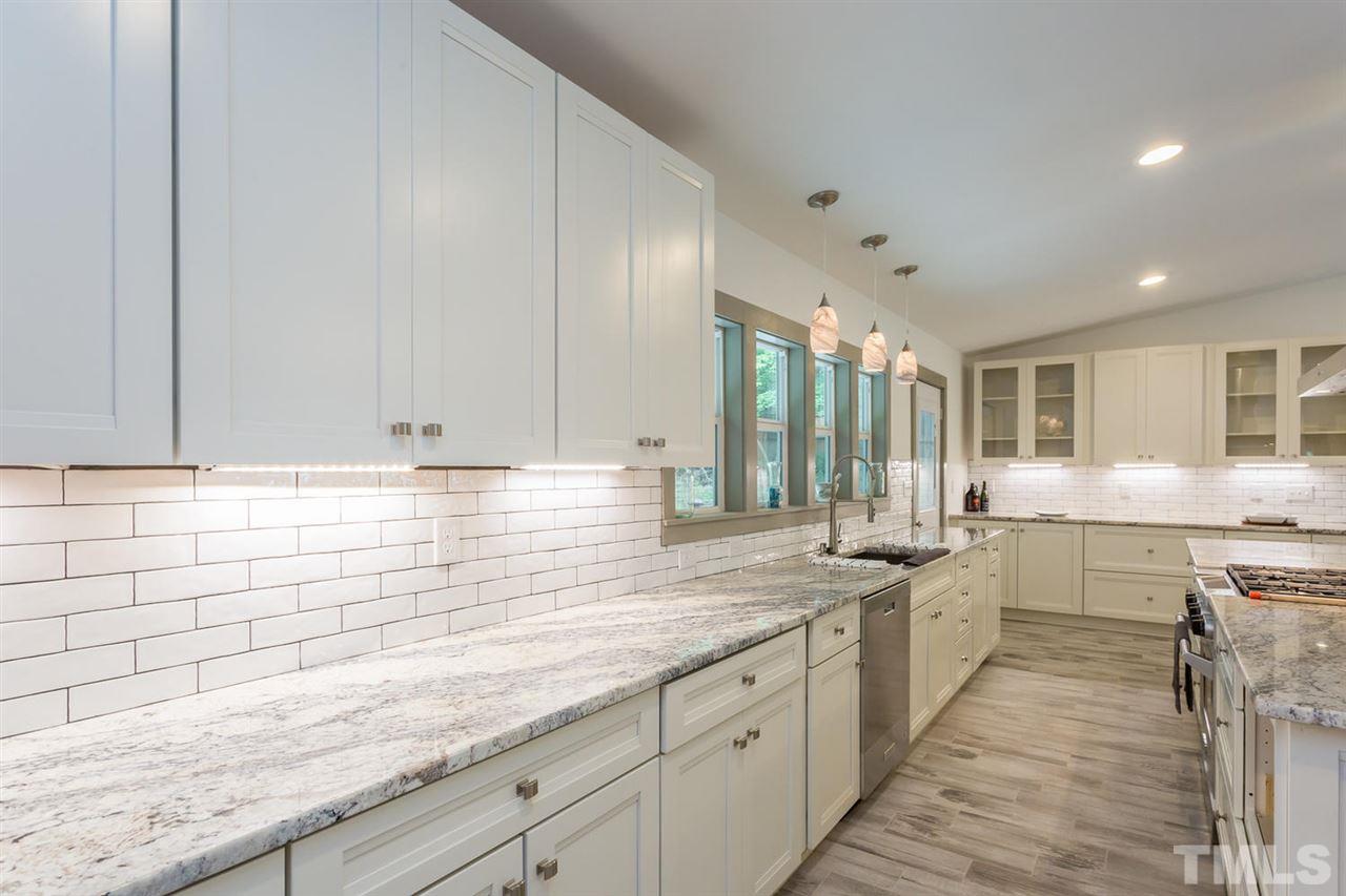 409 Stacy Street Raleigh, NC 27607 - Photo 8 of 25 a kitchen with granite countertop white cabinets and white appliances