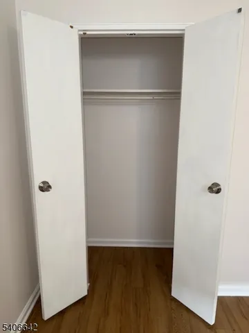 a view of walk in closet with wooden floor
