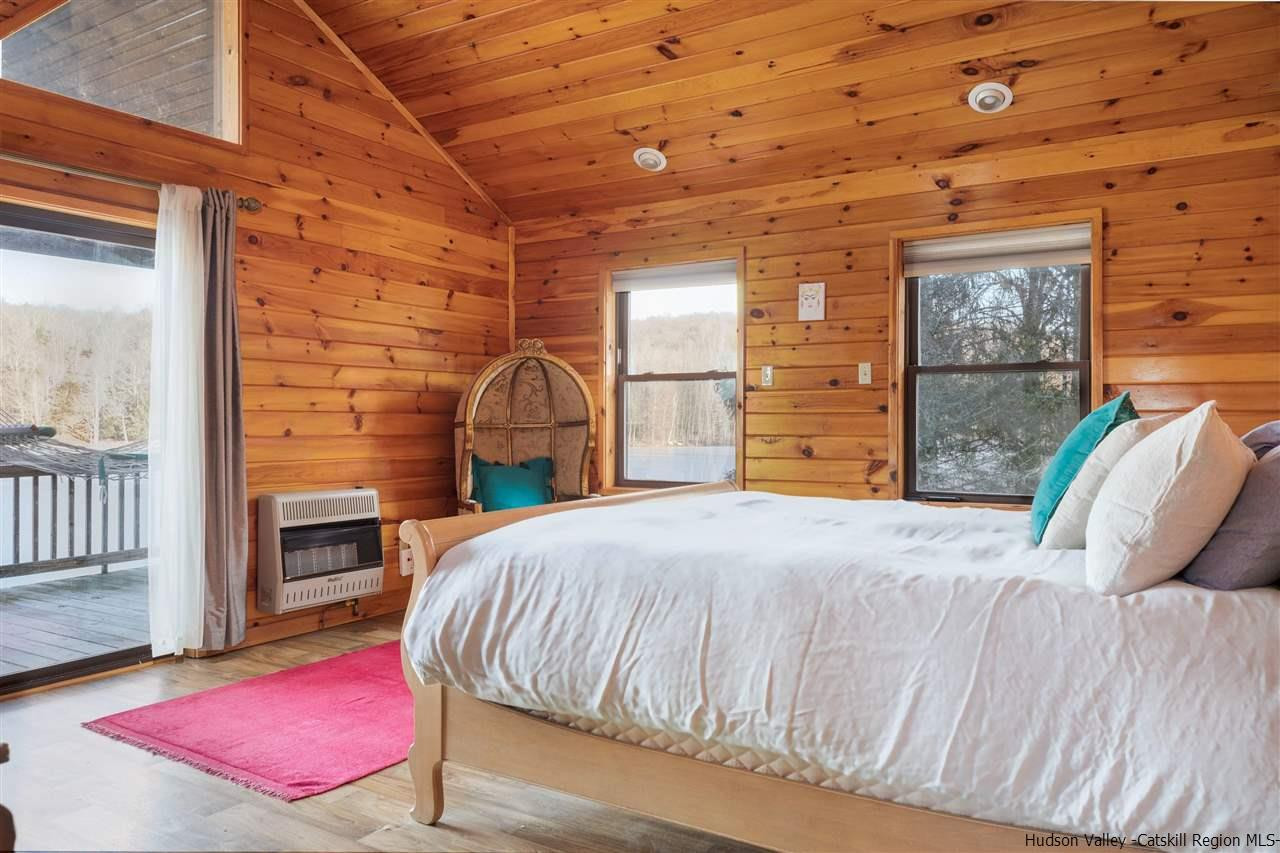 212 Trout Brook Road Roscoe, NY 12776 - Photo 6 of 35 a bedroom with a bed and wooden floor