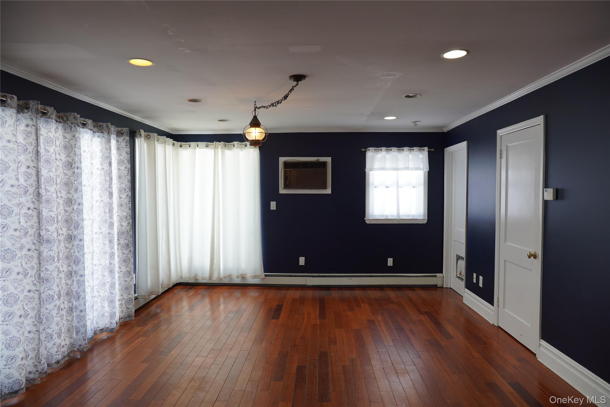 21 Potter Street Patchogue, NY 11772 - Photo 11 of 22 an empty room with wooden floor and windows