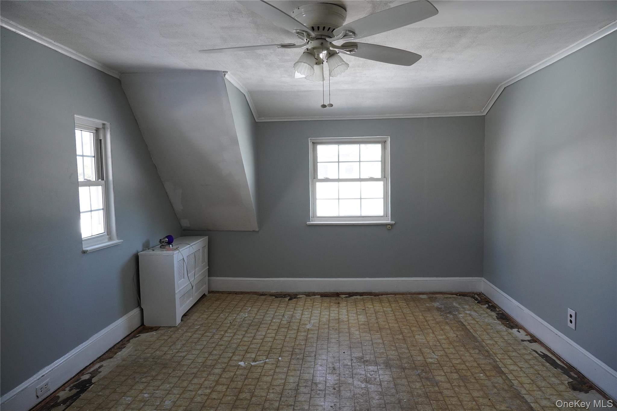21 Potter Street Patchogue, NY 11772 - Photo 17 of 22 an empty room with windows and chandelier fan